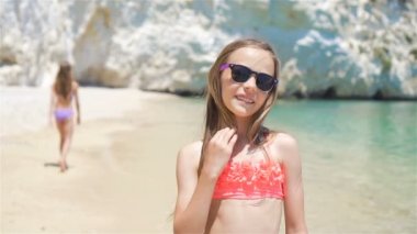 Küçük kızlar yaz tatilinde tropik plajda eğleniyorlar.