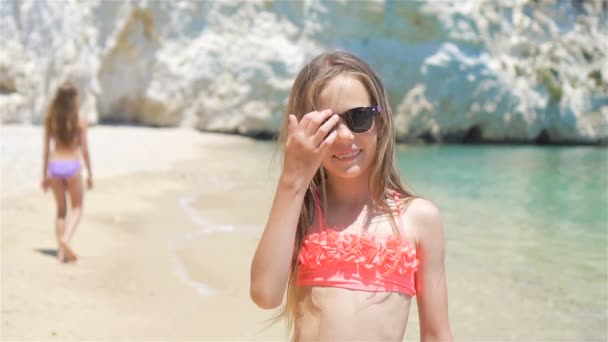 Маленькие девочки веселятся на тропическом пляже во время летних каникул — стоковое видео