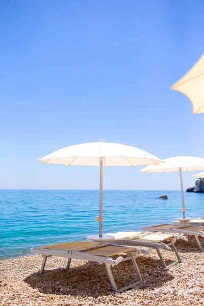 Белый зонтик и шезлонги на тропическом пляже — стоковое фото