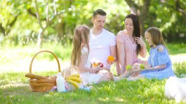 Mutlu aile güneşli bir günde parkta piknik yapıyor.