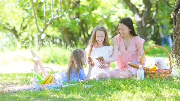 Feliz madre y niñas se relajan junto al lago — Vídeo de stock