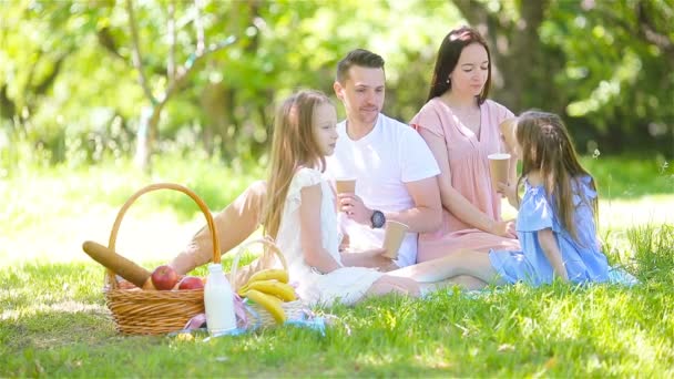 Gelukkige familie op een picknick in het park op een zonnige dag — Stockvideo