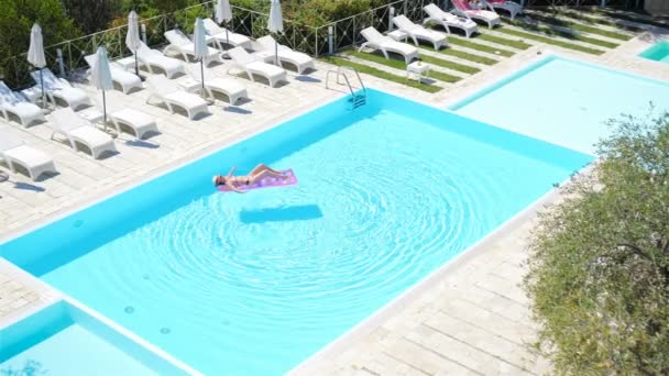 Junge Frau im Bikini-Luftmatratze im großen Pool — Stockvideo