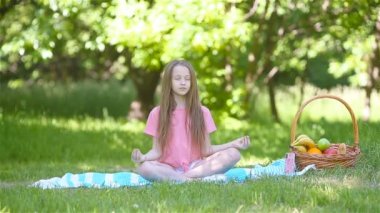 Parkta yoga pozisyonunda küçük bir kız..