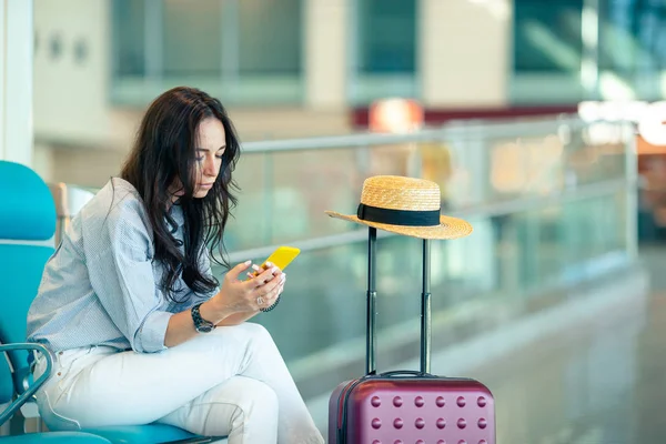 Mujer joven con café en un salón del aeropuerto esperando aviones de vuelo —  Fotos de Stock