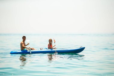 Sportif, çekici bir aile birlikte denizde kayak yapıyor.