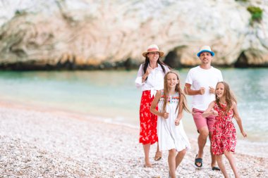 Kumsalda çocukları olan mutlu bir aile.