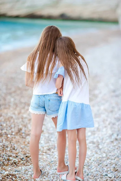 Twee kleine gelukkige meisjes hebben veel plezier op tropische strand spelen samen — Stockfoto