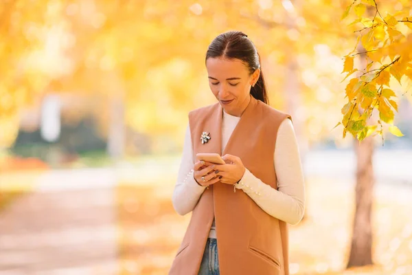 Herfst concept - mooie vrouw die koffie drinkt in het najaar park onder het gebladerte — Stockfoto