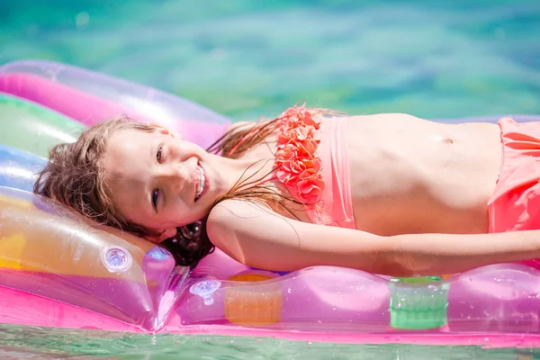 愛らしい女の子オンインフレータブル空気マットレスで海 — ストック写真