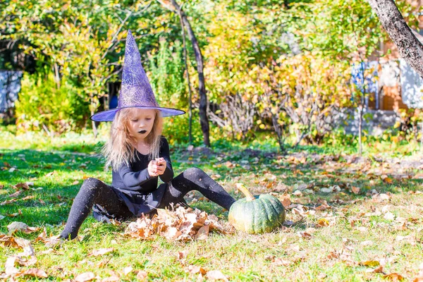 Szczęśliwy mała czarownica zabawy na świeżym powietrzu na Halloween. Cukierek albo psikus. — Zdjęcie stockowe