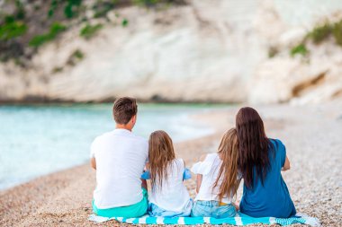 Kumsalda çocukları olan mutlu bir aile.