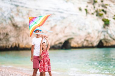 Tropik beyaz plajda aile uçurtması uçuruyoruz.