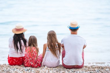 Kumsalda çocukları olan mutlu bir aile.