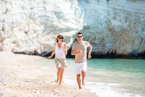 Preciosa pareja caminando por la playa y disfrutando de las vacaciones de verano —  Fotos de Stock