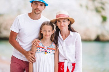 Yaz tatilinde beyaz plajda genç bir aile.
