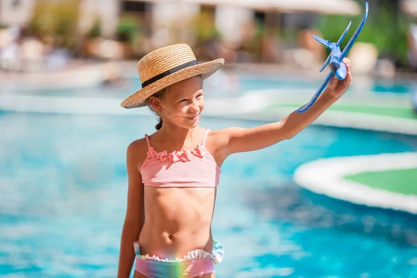 Hermosa niña divirtiéndose cerca de una piscina al aire libre — Foto de Stock