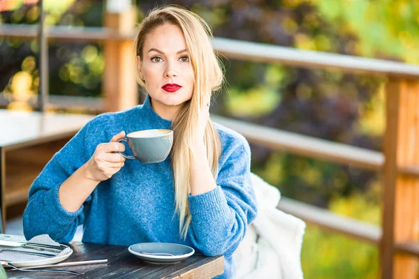Concept d'automne - belle femme buvant du café dans le parc d'automne sous le feuillage d'automne — Photo