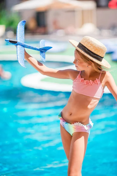 Hermosa niña divirtiéndose cerca de una piscina al aire libre —  Fotos de Stock