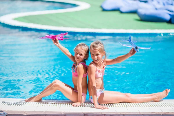 Beautiful little girls having fun near an outdoor pool — Stock Photo, Image