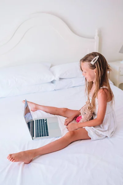 Menina bonito fazendo lição de casa no laptop — Fotografia de Stock
