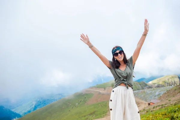 Beautiful happy young woman in mountains in the background of fog — Stock Photo, Image