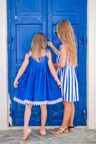 Kleine glückliche Mädchen in Kleidern auf der Straße eines typisch griechischen Dorfes auf der Insel Mykonos, in Griechenland — Stockfoto