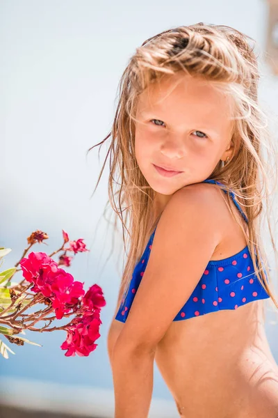 Kleine entzückende Mädchen riechen bunte Blumen am Sommertag — Stockfoto