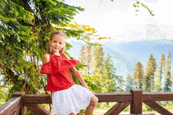 Beautiful happy little girl in mountains in the background of fog — Stock Photo, Image