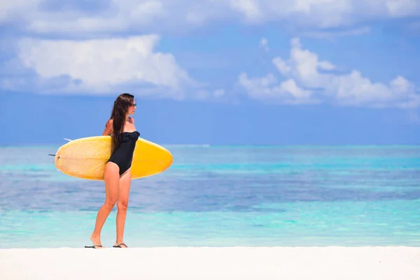 Χαρούμενος νεαρός σερφάρετε γυναίκα στην παραλία με μια σανίδα του σερφ — Φωτογραφία Αρχείου