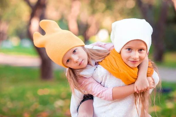 Kleine schattige meisjes met pompoen buiten op een warme herfstdag. — Stockfoto