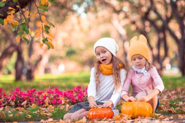 Sıcak bir sonbahar gününde balkabağıyla küçük sevimli kızlar..