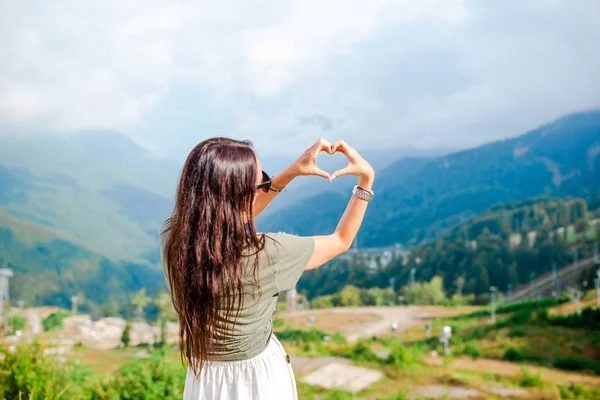 Mulher jovem feliz bonita em montanhas no fundo do nevoeiro — Fotografia de Stock