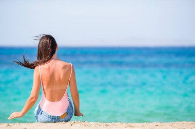 Plajda uzanan kadın yaz tatilinin tadını çıkarıyor ve denize bakıyor.