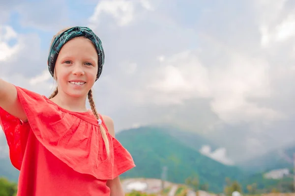 Krásná šťastná holčička v horách v pozadí mlhy — Stock fotografie