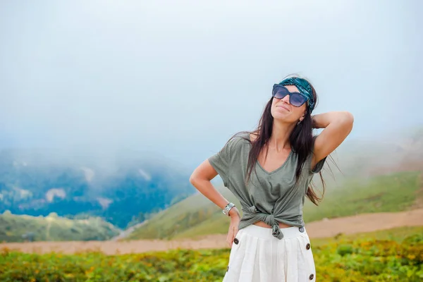 Beautiful happy young woman in mountains in the background of fog — Stock Photo, Image