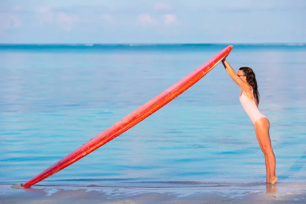 Glücklich schöne Surferin Mädchen am Strand mit ihrem Surfbrett — Stockfoto