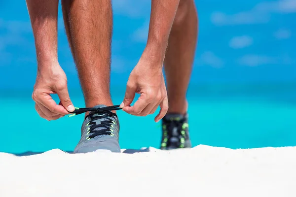 Joven corredor masculino preparándose para comenzar en la playa blanca — Foto de Stock