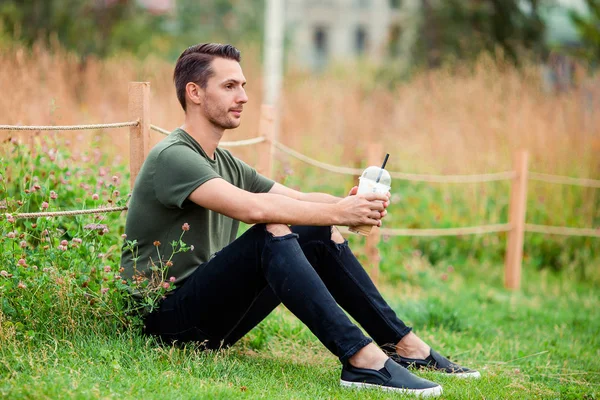 Happy young urban man with book outdoors — Stock Photo, Image