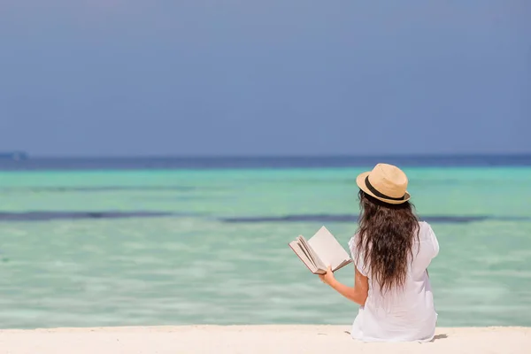 Ritratto di una giovane donna che si rilassa sulla spiaggia, leggendo un libro — Foto Stock