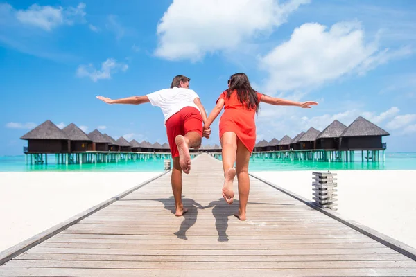 Pareja joven en el muelle de la playa en la isla tropical en luna de miel —  Fotos de Stock