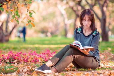 Genç kadın güzel sonbahar park bir kitap okuma