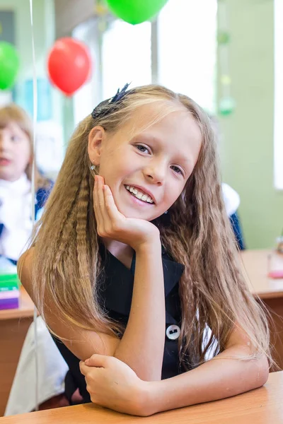Schattige kleine schoolmeisje in haar klas aan de tafel — Stockfoto