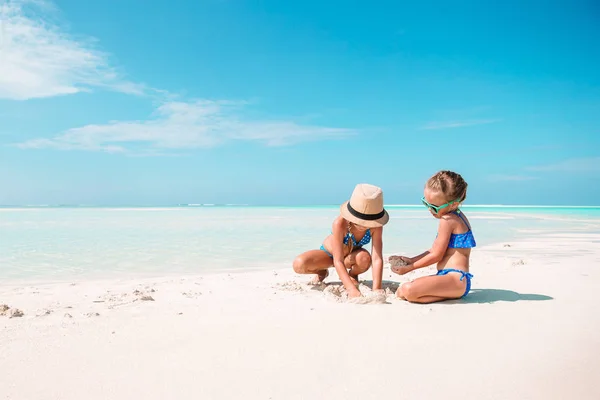 Twee kleine gelukkige meisjes hebben veel plezier op tropische strand spelen samen — Stockfoto