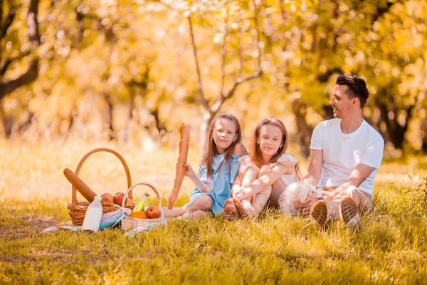 Gelukkige vader en kleine dochters ontspannen bij het meer — Stockfoto