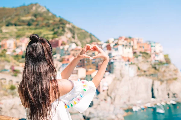 Happy girl podejmowania z rąk kształt serca na starej nadmorskiej miejscowości w Parku Narodowym Cinque Terre. — Zdjęcie stockowe