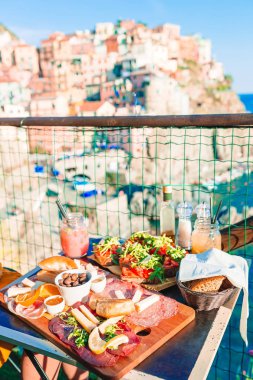 Lezzetli İtalyan atıştırmalıkları. Manarola manzaralı kafede gemide taze bruschettes, peynir ve et