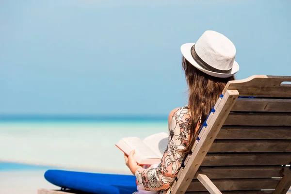 Portret van een jonge vrouw ontspannen op het strand, het lezen van een boek — Stockfoto
