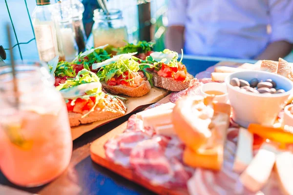 Tasty italian snack. Fresh bruschettes, cheeses and meat on the board in cafe with view in Manarola — Stock Photo, Image