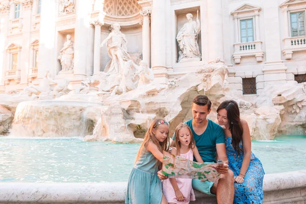 Szczęśliwa rodzina w pobliżu Fontana di Trevi z mapą miasta — Zdjęcie stockowe